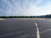 there is an empty airport parking lot with no cars on it and a stop sign on the end