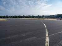 there is an empty airport parking lot with no cars on it and a stop sign on the end