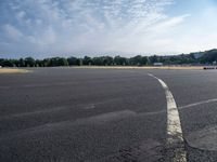 there is an empty airport parking lot with no cars on it and a stop sign on the end