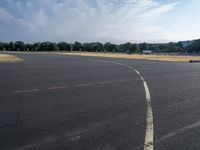 there is an empty airport parking lot with no cars on it and a stop sign on the end