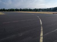 there is an empty airport parking lot with no cars on it and a stop sign on the end