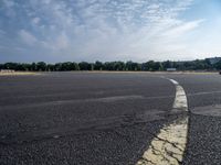 there is an empty airport parking lot with no cars on it and a stop sign on the end