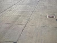 an airport runway and the control tower are empty, as seen from above the plane