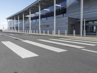 the empty streets of a very wide airport terminal building with a clear blue sky in the background