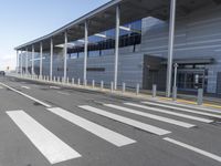 the empty streets of a very wide airport terminal building with a clear blue sky in the background