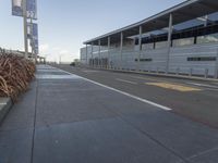 the empty streets of a very wide airport terminal building with a clear blue sky in the background