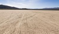 an empty barren area with some mountains in the background at death valley national park, death valley national park