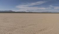 an empty barren area with some mountains in the background at death valley national park, death valley national park