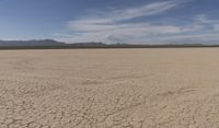 an empty barren area with some mountains in the background at death valley national park, death valley national park