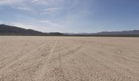 an empty barren area with some mountains in the background at death valley national park, death valley national park