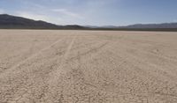 an empty barren area with some mountains in the background at death valley national park, death valley national park