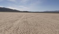 an empty barren area with some mountains in the background at death valley national park, death valley national park