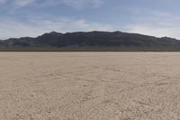 an empty barren area with some mountains in the background at death valley national park, death valley national park