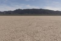 an empty barren area with some mountains in the background at death valley national park, death valley national park