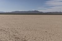 an empty barren area with some mountains in the background at death valley national park, death valley national park