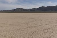 an empty barren area with some mountains in the background at death valley national park, death valley national park