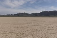 an empty barren area with some mountains in the background at death valley national park, death valley national park