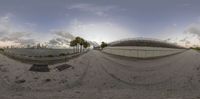 a fish eye view of an empty beach area with trees and buildings near by the ocean