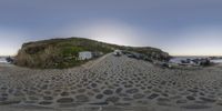 a fisheye lens image of an empty beach side road in the sand with a truck parked on it