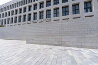 a empty bench sitting in front of an office building next to a large brick walkway