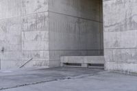 there is a empty bench outside of an old building with concrete walls and cement flooring