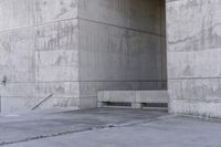 there is a empty bench outside of an old building with concrete walls and cement flooring