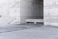 there is a empty bench outside of an old building with concrete walls and cement flooring