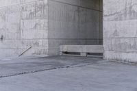 there is a empty bench outside of an old building with concrete walls and cement flooring