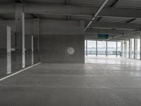 an empty building with concrete floors, two circular windows and a window in the center