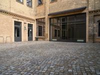 there is an empty courtyard between two buildings that are being converted into apartments and the doors are closed