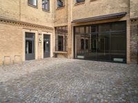 there is an empty courtyard between two buildings that are being converted into apartments and the doors are closed