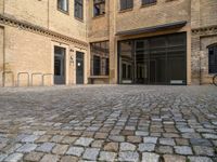 there is an empty courtyard between two buildings that are being converted into apartments and the doors are closed