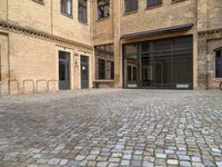 there is an empty courtyard between two buildings that are being converted into apartments and the doors are closed