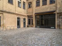 there is an empty courtyard between two buildings that are being converted into apartments and the doors are closed