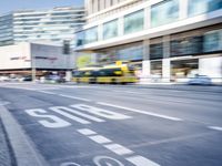 a blurry picture of an empty street with cars on it and buildings in the background