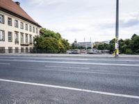 there are no cars parked at the curb on this road while other vehicles are parked on the street