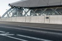 the bike path next to the building is empty while others travel through the frame of the building