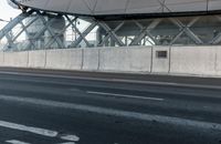 the bike path next to the building is empty while others travel through the frame of the building