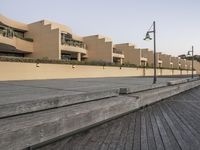 an empty boardwalk in front of a building with a number of buildings on one side