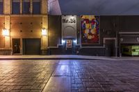 an empty alley with brick walkway and large poster of a woman standing at the door
