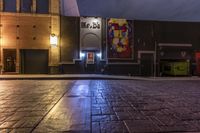 an empty alley with brick walkway and large poster of a woman standing at the door