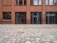 a view of an empty brick floor from the street with the entrance door open and no sign