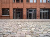 a view of an empty brick floor from the street with the entrance door open and no sign