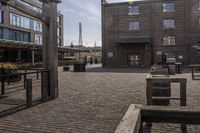 a brick parking lot is empty and full of benches and buildings in front of a building