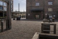 a brick parking lot is empty and full of benches and buildings in front of a building