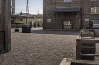 a brick parking lot is empty and full of benches and buildings in front of a building