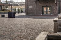 a brick parking lot is empty and full of benches and buildings in front of a building