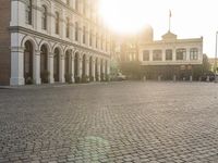 a man is standing in an empty brick street at sunrise time, taking a picture