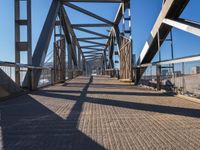 a view from the underside of an empty bridge looking at a crosswalk on a sunny day