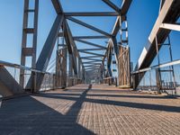 a view from the underside of an empty bridge looking at a crosswalk on a sunny day